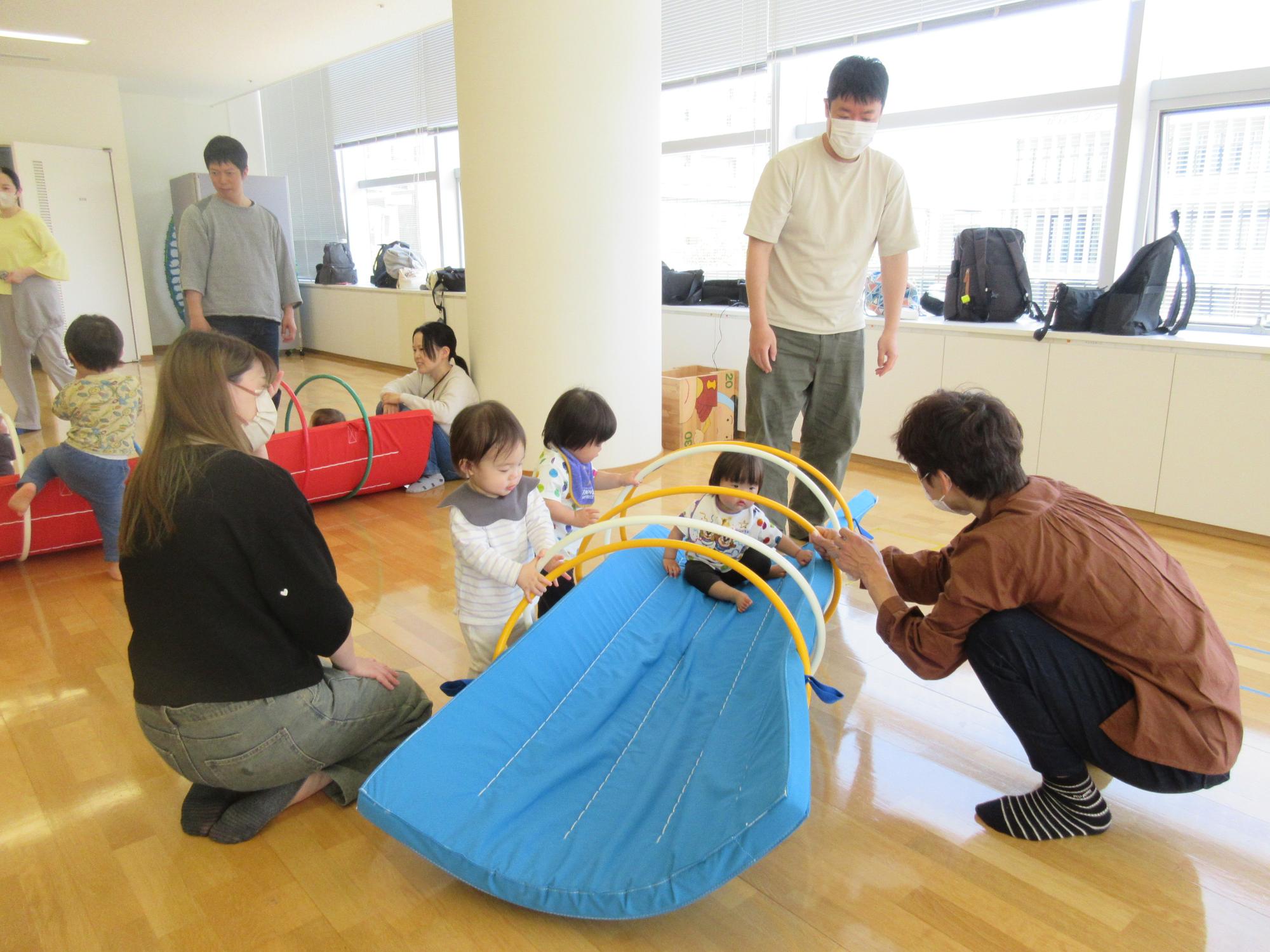 親子でマットトンネルで遊ぶ様子