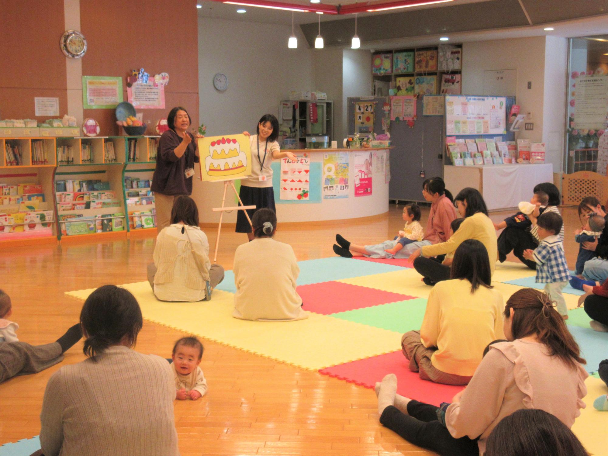 みんなで大型絵本に合わせて親子でふれ合っている様子