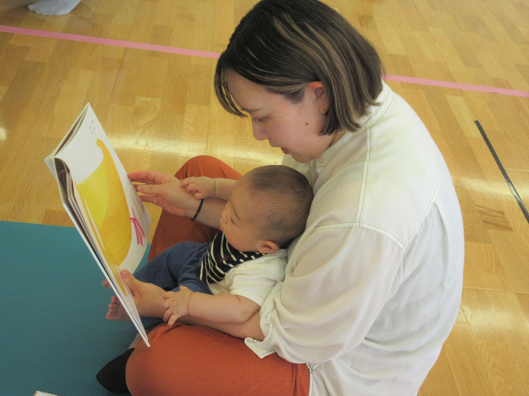 お気に入りの絵本を見つけて、親子で読んでいる様子