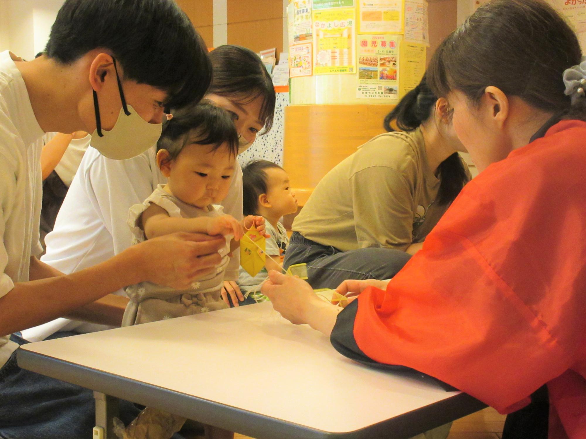 ミニミニ屋台であてくじをする親子の様子