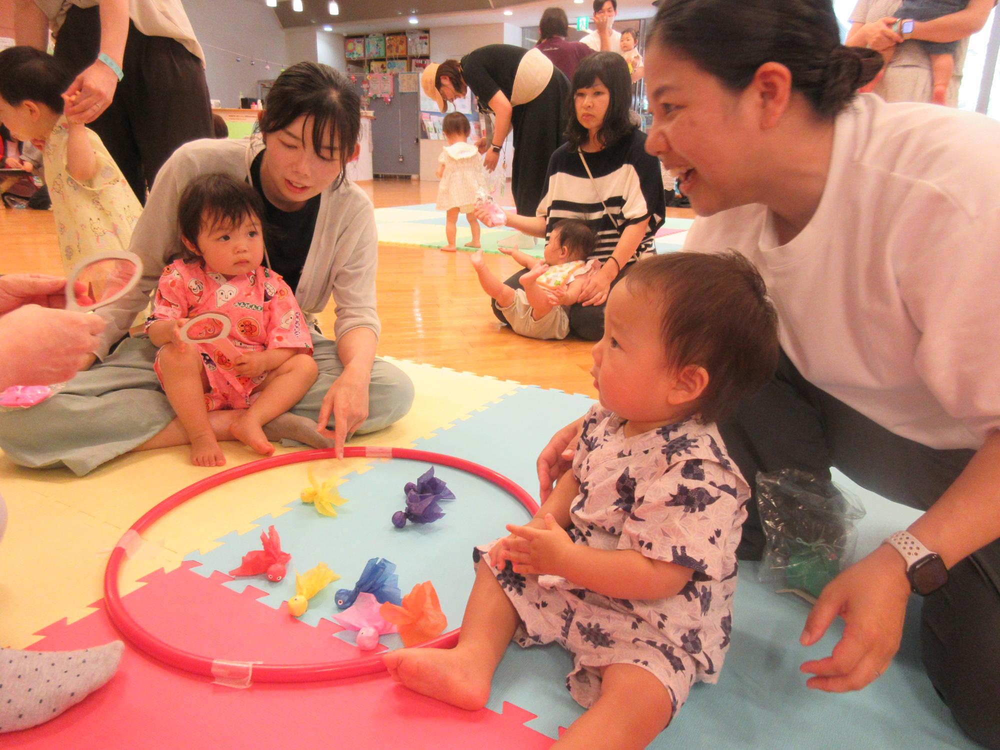 ミニミニ縁日で金魚すくいを親子でする様子