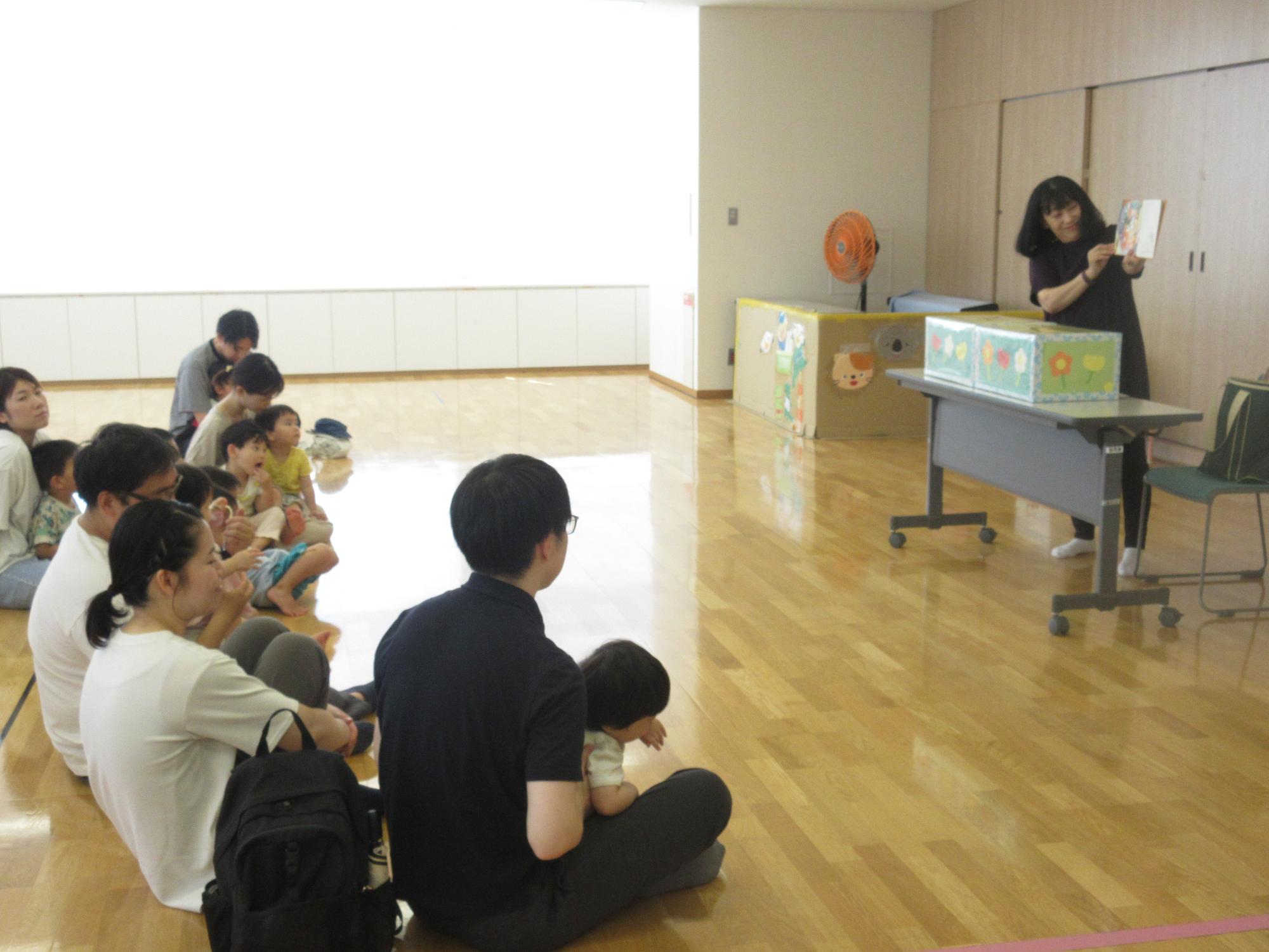 親子で絵本を楽しむ会で「めっきらもっきらどんどん」を観ている様子