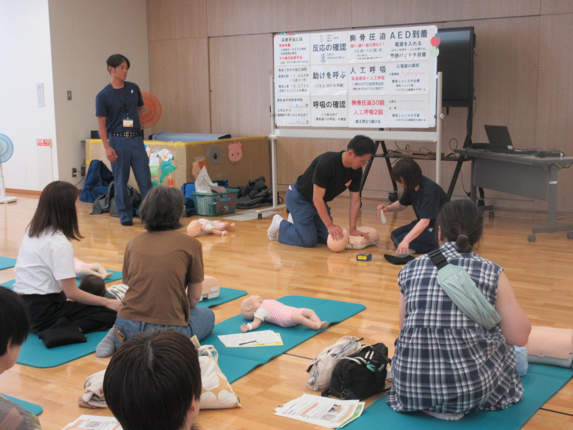 子育て学習会で心肺蘇生をする様子を観る親子の様子
