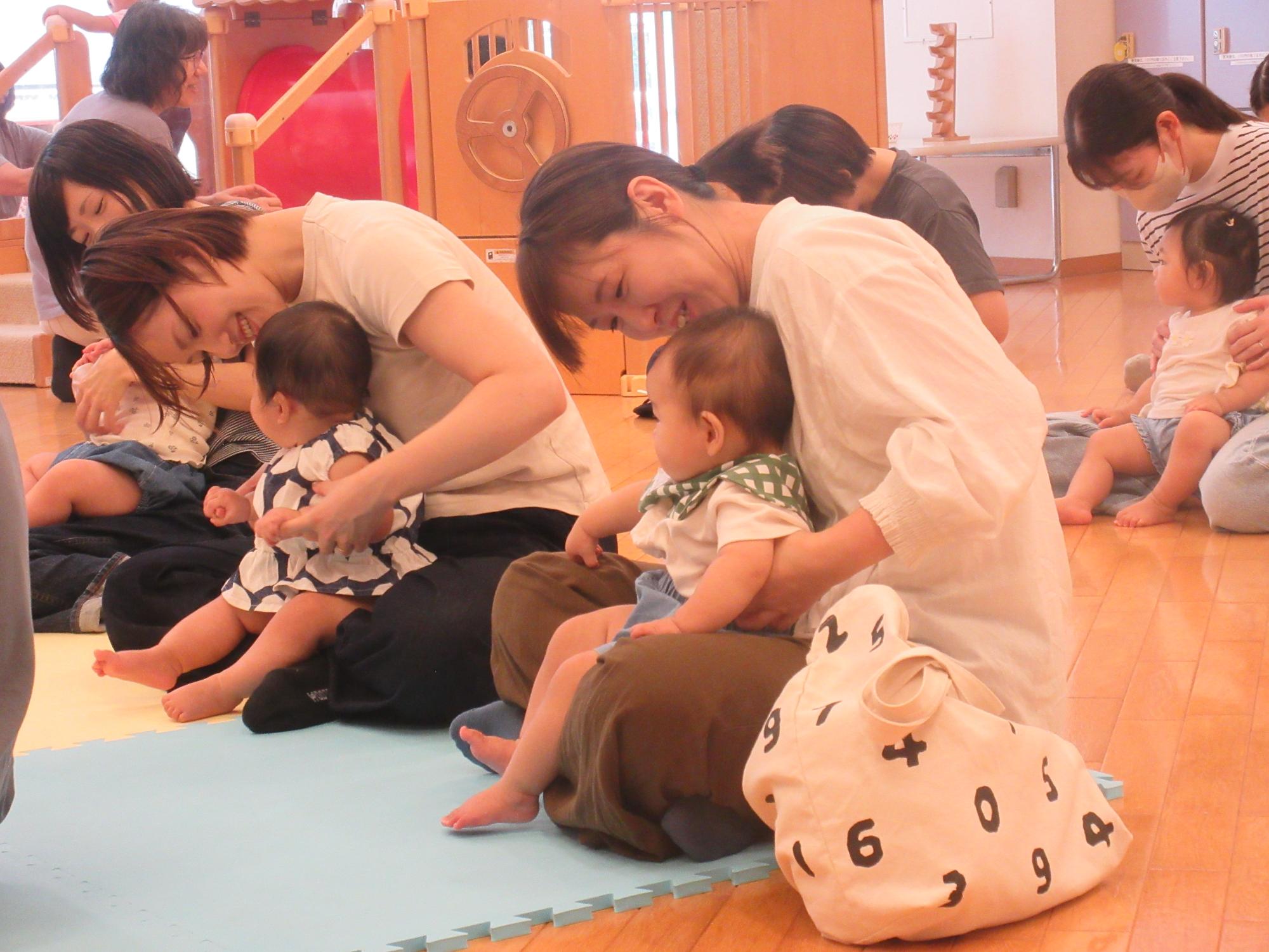 親子でふれ合いながら、季節の歌を楽しんでいる様子