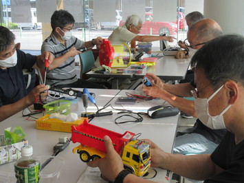 車のおもちゃなどさまざまなおもちゃを修理している「松江おもちゃの病院」の人たちの写真
