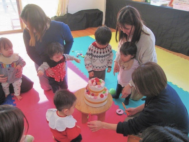 布のケーキを囲んで、誕生会を楽しんでいる様子