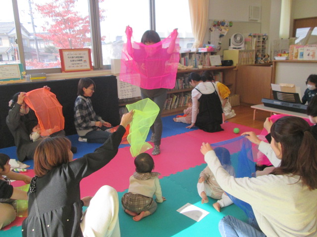 うりぼうず広場でオーガンジーを使ってふれあい遊びを楽しんでいる様子