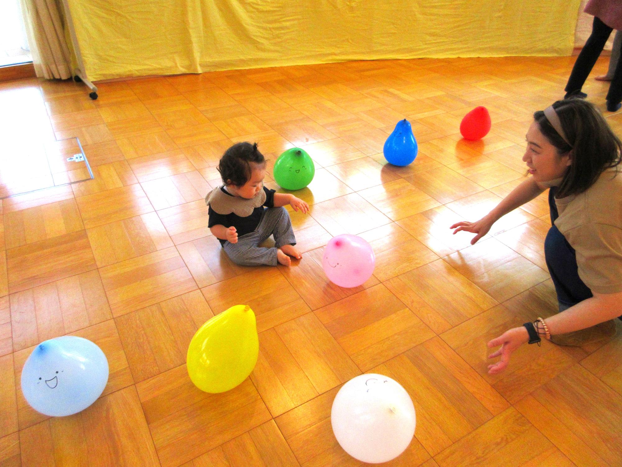 「ちびあおむしくんの日」風船を使ったふれあい遊びを楽しむ親子の写真