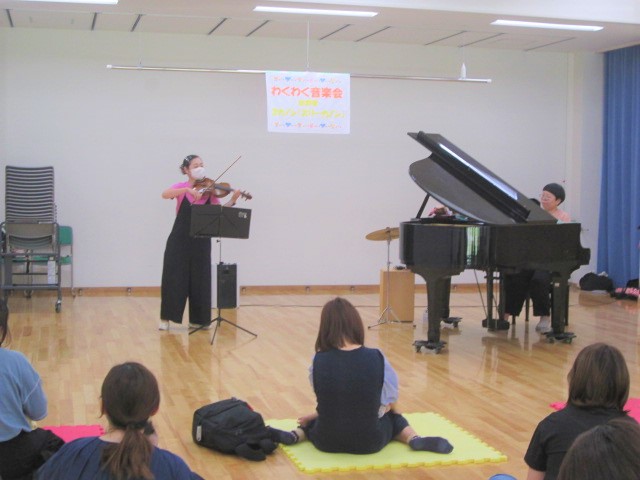 バイオリンやピアノの音色を親子でゆったりと聴いている様子