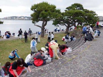 湖付近の芝生や通りの清掃をしている人たちの写真