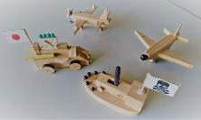 木材で作られた飛行機や船などの乗り物が並んでいる写真