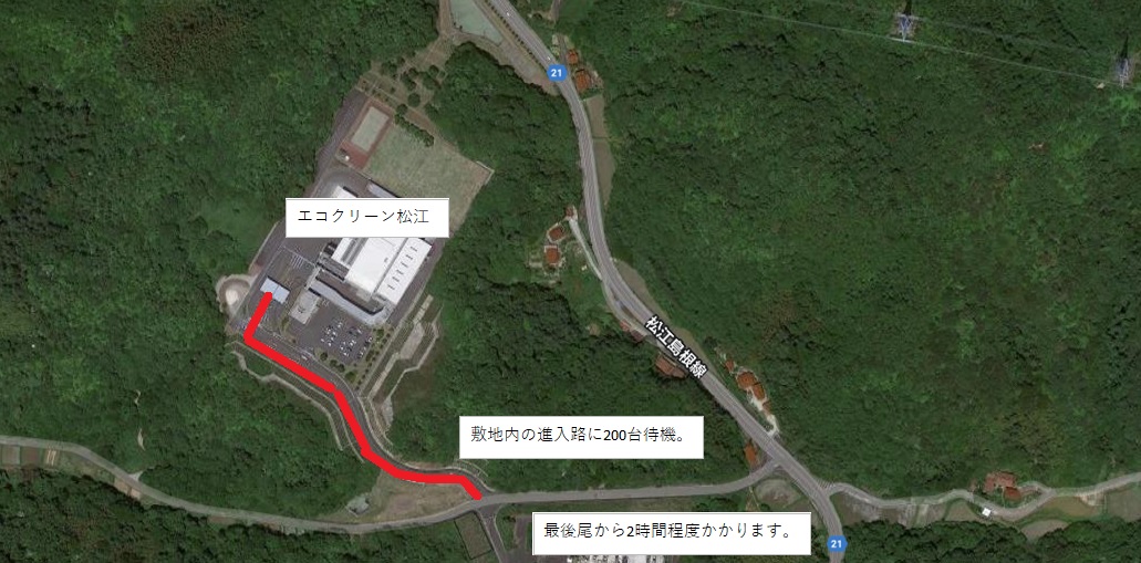 山々に囲まれたエコクリーン松江に続く進入路に200台車両が待機していることを示す赤い線と、「最後尾から2時間程度かかります」と記載された航空写真の画像