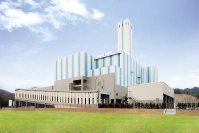 煙突が立っているエコクリーン松江工場棟を正面から見た建物の外観の写真