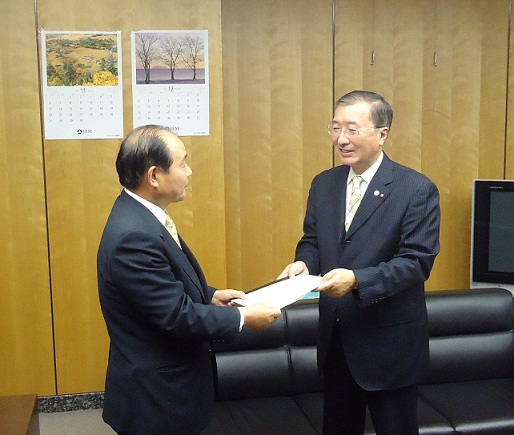 スーツを着た松浦松江市長が福田総務大臣政務官に申出書を手渡す様子の写真