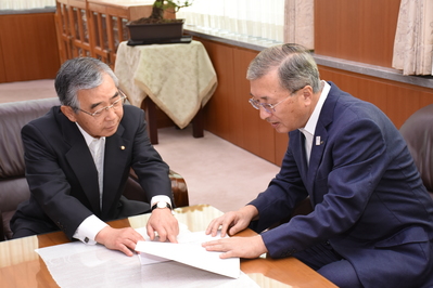 溝口善兵衛島根県知事から同意書の説明を受ける松浦正敬松江市長の写真