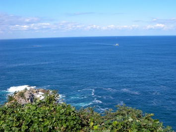 水色の空と、濃い青色の日本海が一面に広がっている写真
