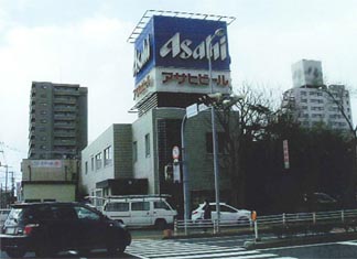 建物の上に大きなアサヒビールの看板が設置されたアサヒビール株式会社の外観写真